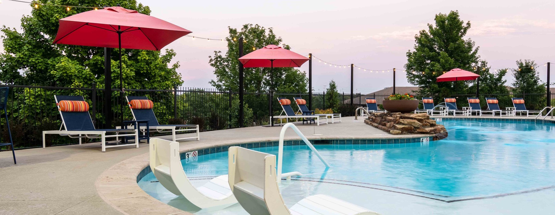resort style pool with seating and trees behind