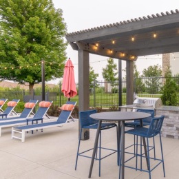 a grill area with a table and chairs