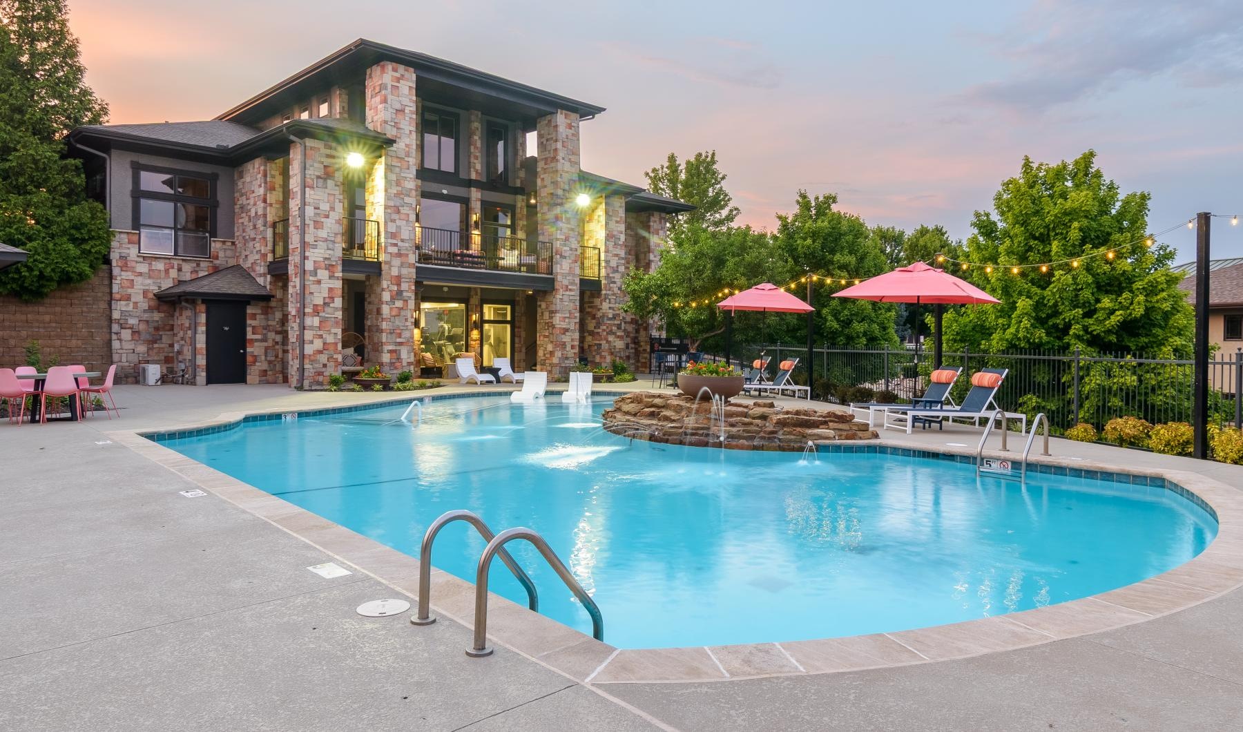 a swimming pool with chairs and umbrellas